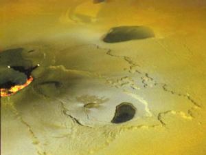 "An active volcanic eruption on Jupiter’s moon Io was captured in this false color image taken on February 22, 2000 by NASA’s Galileo spacecraft. White and orange areas on the left side of the picture show newly erupted hot lava. The two small bright spots are sites where molten rock is exposed to the surface at the toes of lava flows. The larger orange and yellow ribbon is a cooling lava flow that is more than more than 60 kilometers (37 miles) long. Volcano on Io