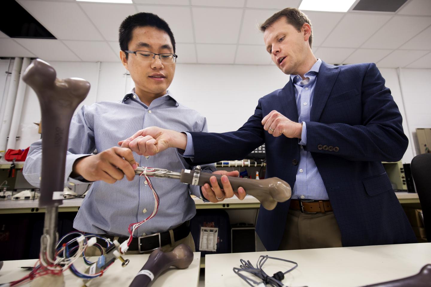 University of Michigan's Dr. Jerome Lynch examines a prototype of their smart artificial limbs with research fellow Wentao Wang.