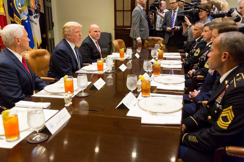 US President Donald Trump sits at a table with military advisors, perhaps discussing the climate change national security strategy.