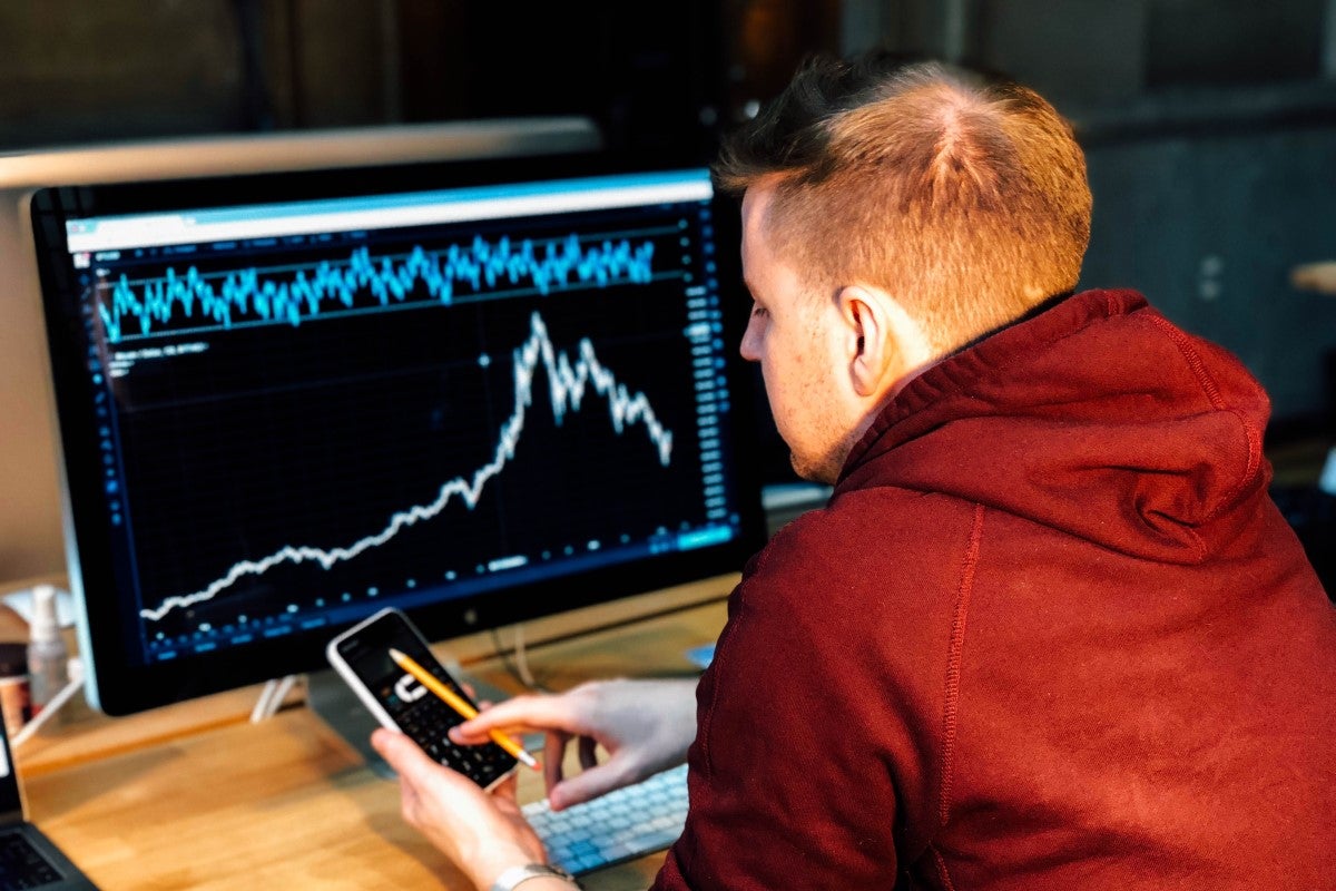 Man at computer investing.