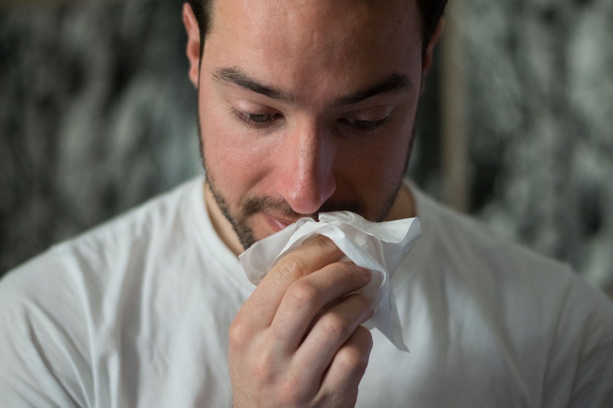 Man wiping his nose.