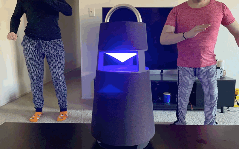 Two humans and a cat dancing to the music and lights of the LG XBOOM 360 Bluetooth speaker. 